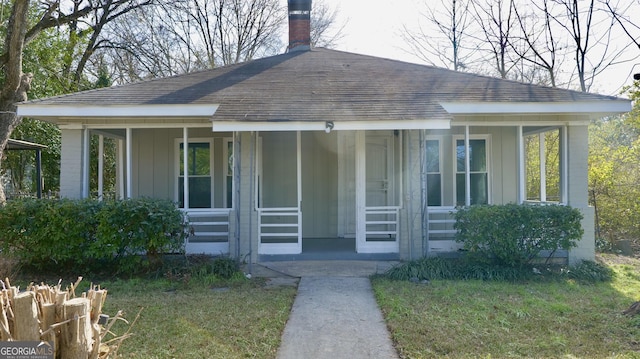 view of front of home with covered porch and a front lawn