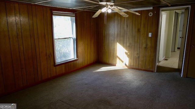 empty room with wood walls, light carpet, and a wealth of natural light