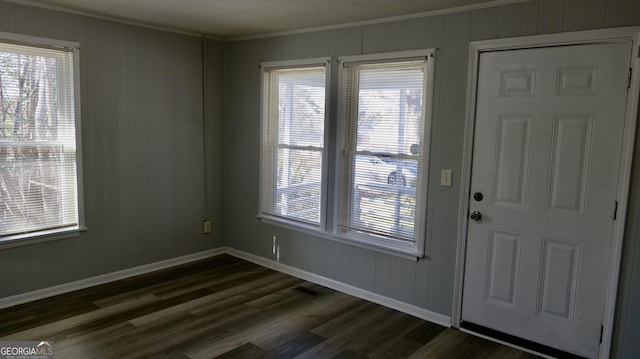 foyer entrance featuring crown molding, plenty of natural light, and dark wood-type flooring