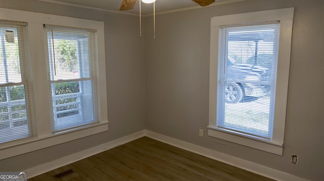 unfurnished room with crown molding, dark wood-type flooring, and ceiling fan