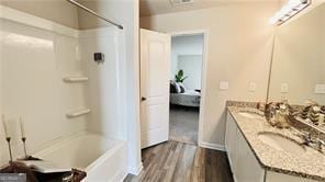 720 Dove Tree Ln, Social Circle, GA 30025 - bathroom with shower / bathtub combination, vanity, and hardwood / wood-style floors