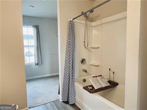 720 Dove Tree Ln, Social Circle, GA 30025 - bathroom featuring shower / bath combo with shower curtain