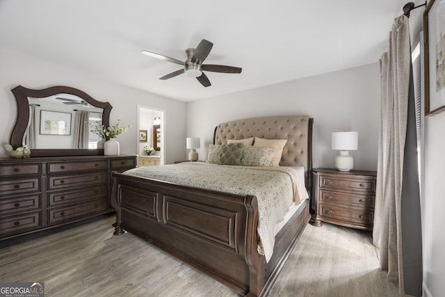 bedroom featuring connected bathroom, hardwood / wood-style flooring, and ceiling fan