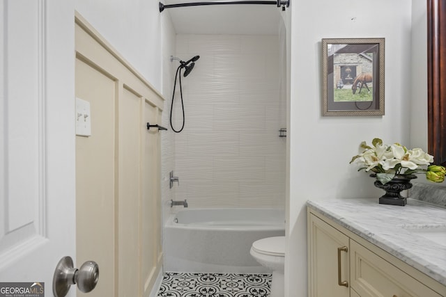 full bathroom featuring vanity, tiled shower / bath, tile patterned floors, and toilet