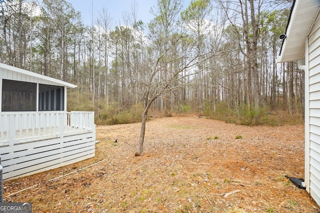 view of yard featuring a sunroom and a deck