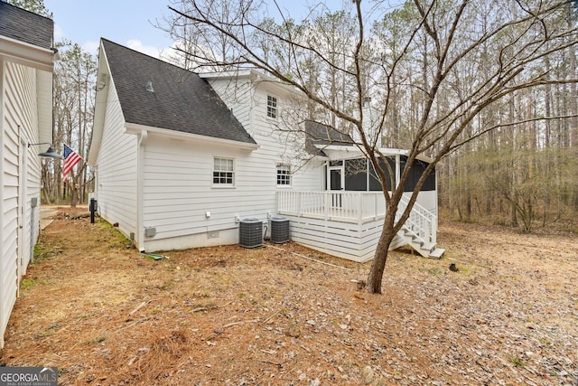 rear view of house with cooling unit and a wooden deck