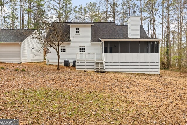 rear view of property featuring central AC unit and a sunroom