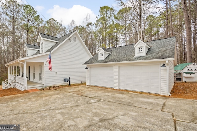 view of property exterior featuring an outbuilding, a porch, and a garage