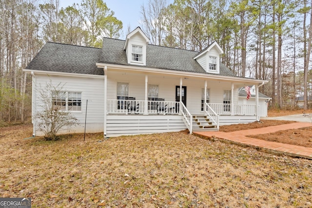 cape cod home featuring covered porch