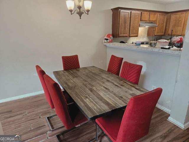 dining room with an inviting chandelier and dark wood-type flooring