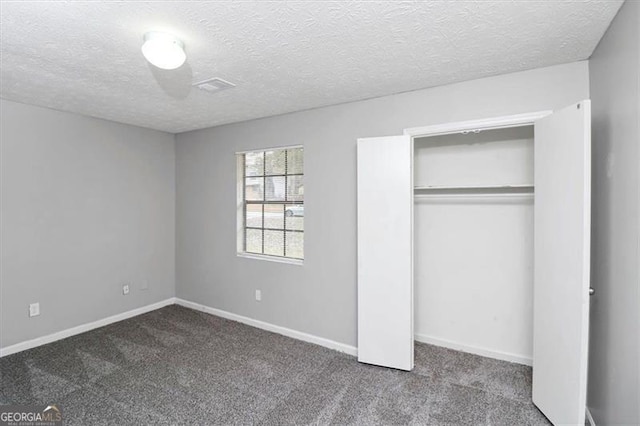 unfurnished bedroom featuring carpet floors, a closet, and a textured ceiling