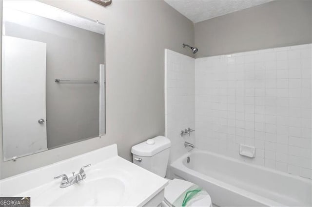 full bathroom featuring  shower combination, toilet, a textured ceiling, and vanity