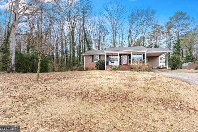 ranch-style house featuring a porch and a carport