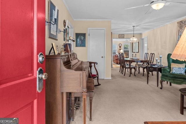 carpeted entrance foyer featuring ornamental molding and ceiling fan