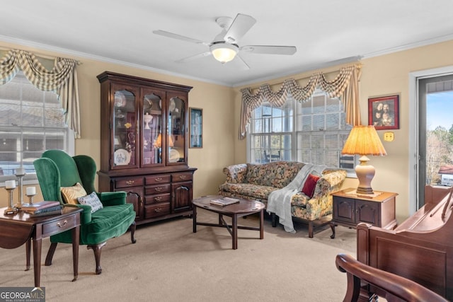 sitting room featuring ornamental molding, plenty of natural light, light colored carpet, and ceiling fan