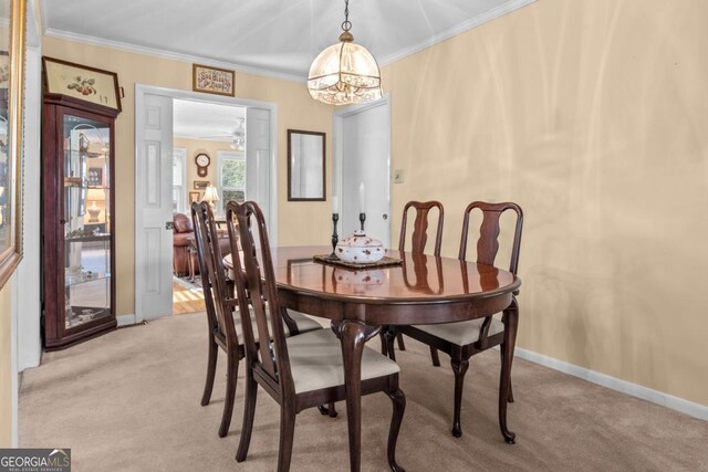 dining space featuring ornamental molding and light colored carpet