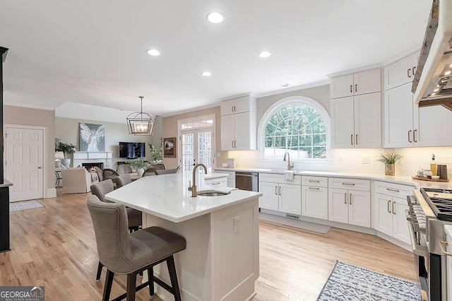 kitchen with white cabinetry, an island with sink, appliances with stainless steel finishes, and sink