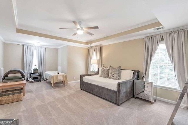 bedroom with a tray ceiling, ornamental molding, ceiling fan, and carpet