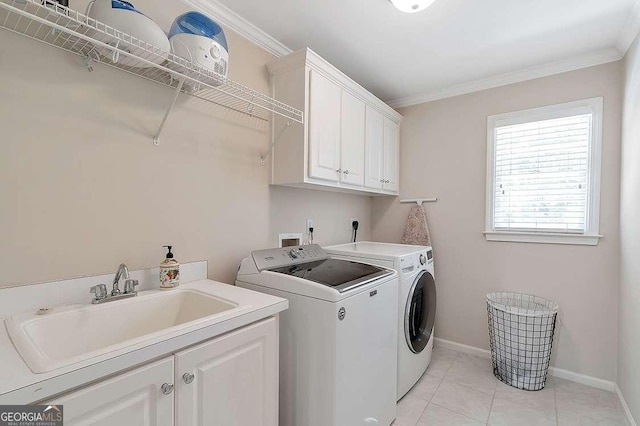 laundry area with cabinets, washing machine and dryer, sink, and ornamental molding