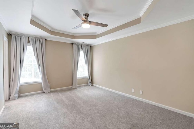 carpeted spare room featuring ornamental molding, ceiling fan, and a tray ceiling