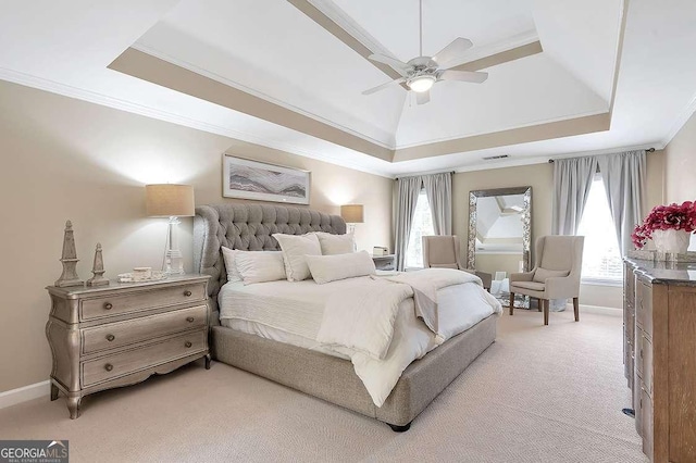 bedroom with light carpet, a tray ceiling, and crown molding