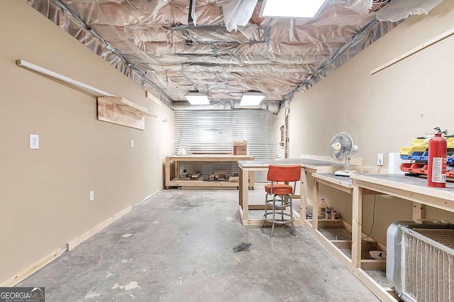 basement featuring a workshop area and baseboards