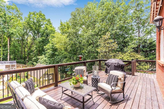 wooden deck with an outdoor living space and area for grilling