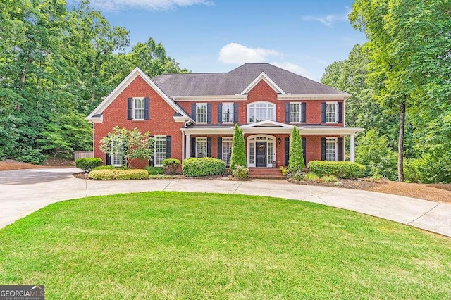 view of front of home with concrete driveway, brick siding, and a front yard