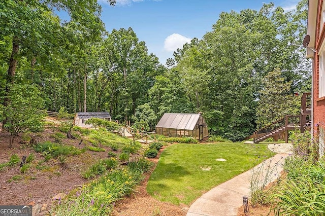 view of yard featuring an exterior structure, an outdoor structure, and stairway