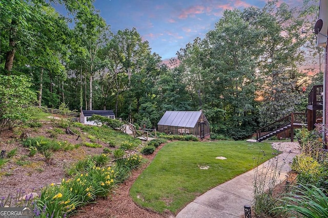 view of yard with a greenhouse, an outdoor structure, and stairs