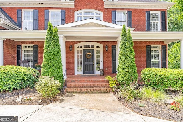 view of exterior entry featuring brick siding