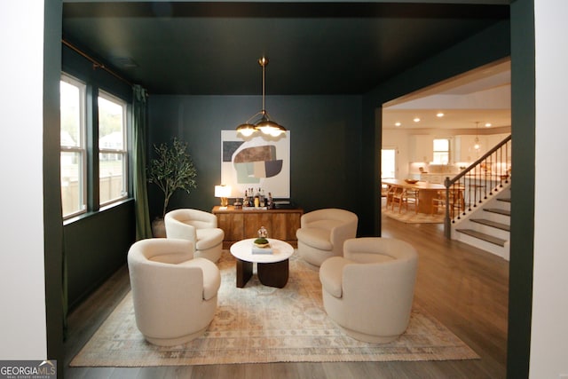 sitting room with stairway, wood finished floors, and recessed lighting