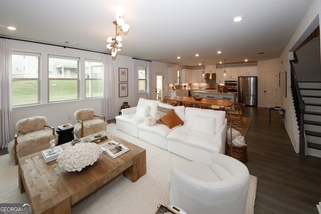 living room featuring dark wood-type flooring, recessed lighting, and stairway