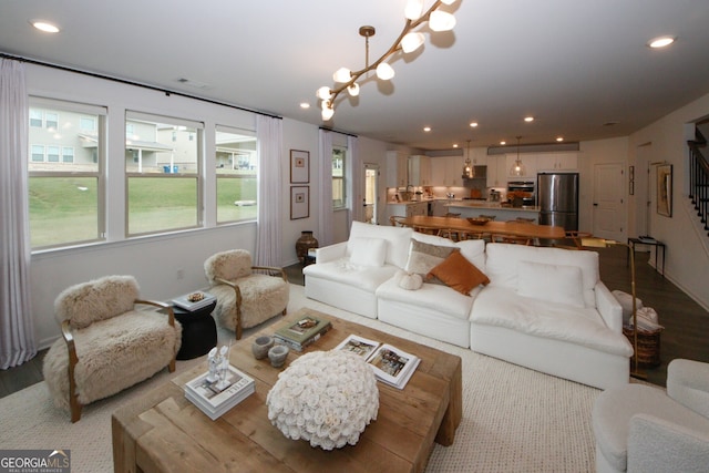 living room featuring light wood-style floors, recessed lighting, visible vents, and an inviting chandelier