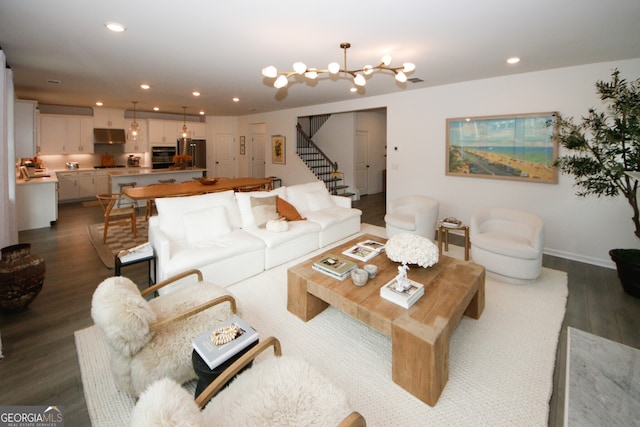 living area featuring recessed lighting, dark wood-style flooring, a notable chandelier, and stairway