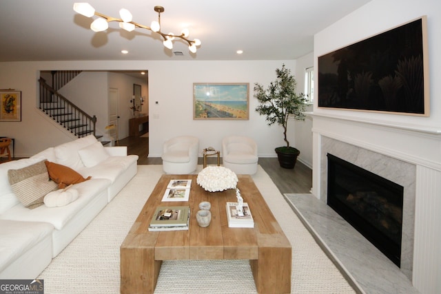 living room with light wood-type flooring, stairs, a fireplace, and recessed lighting