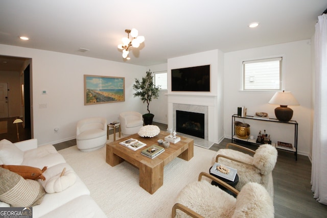 living area featuring a fireplace, a chandelier, wood finished floors, and recessed lighting