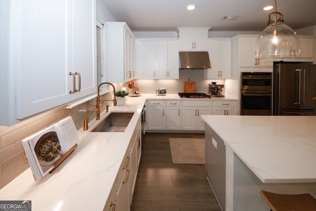 kitchen featuring pendant lighting, stainless steel appliances, white cabinets, a sink, and under cabinet range hood