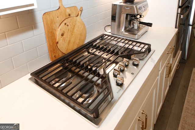 interior details featuring tasteful backsplash, light countertops, and stainless steel gas stovetop