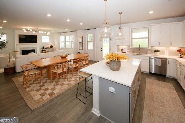 kitchen featuring a sink, white cabinetry, light countertops, a center island, and dishwasher