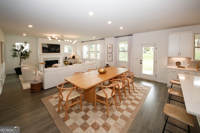 dining space with dark wood-style floors, a fireplace, visible vents, and recessed lighting