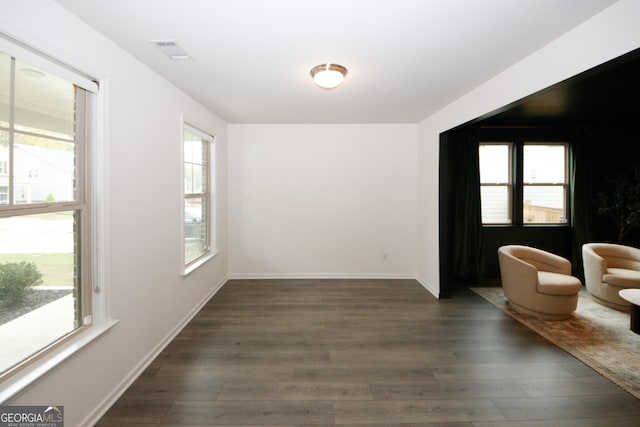 interior space with baseboards, visible vents, and dark wood-style flooring