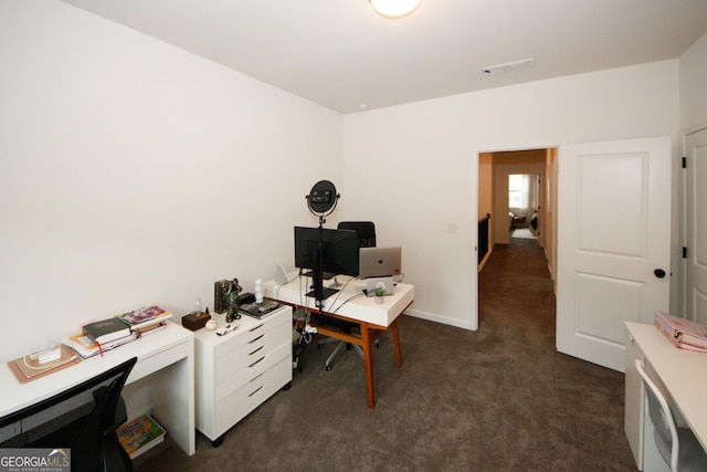 office space with visible vents, dark carpet, and baseboards