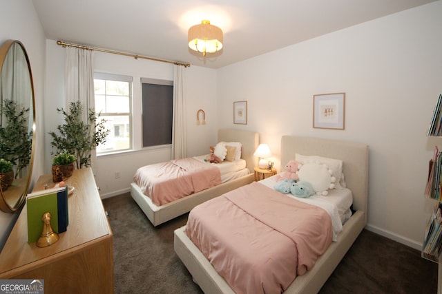 bedroom featuring dark colored carpet and baseboards