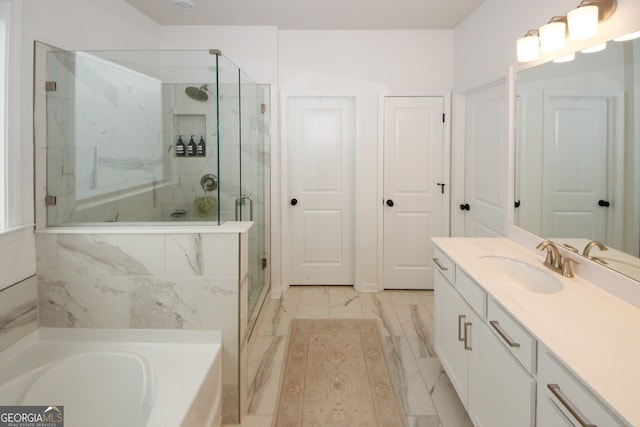 bathroom featuring marble finish floor, a garden tub, vanity, and a shower stall