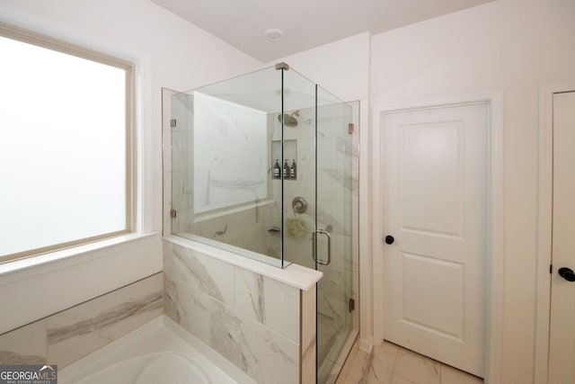 full bathroom featuring marble finish floor, a stall shower, and a bathtub