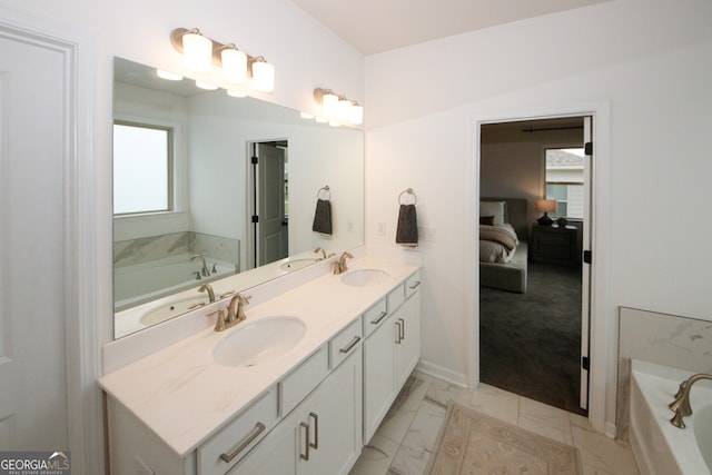 full bathroom with connected bathroom, marble finish floor, a garden tub, and a sink