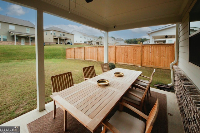 view of patio / terrace with ceiling fan, a residential view, fence, and outdoor dining area