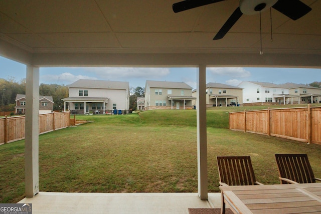 view of yard with ceiling fan, a patio area, fence, and a residential view