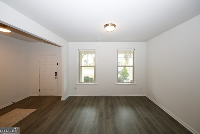 foyer with dark wood-style floors, visible vents, and baseboards